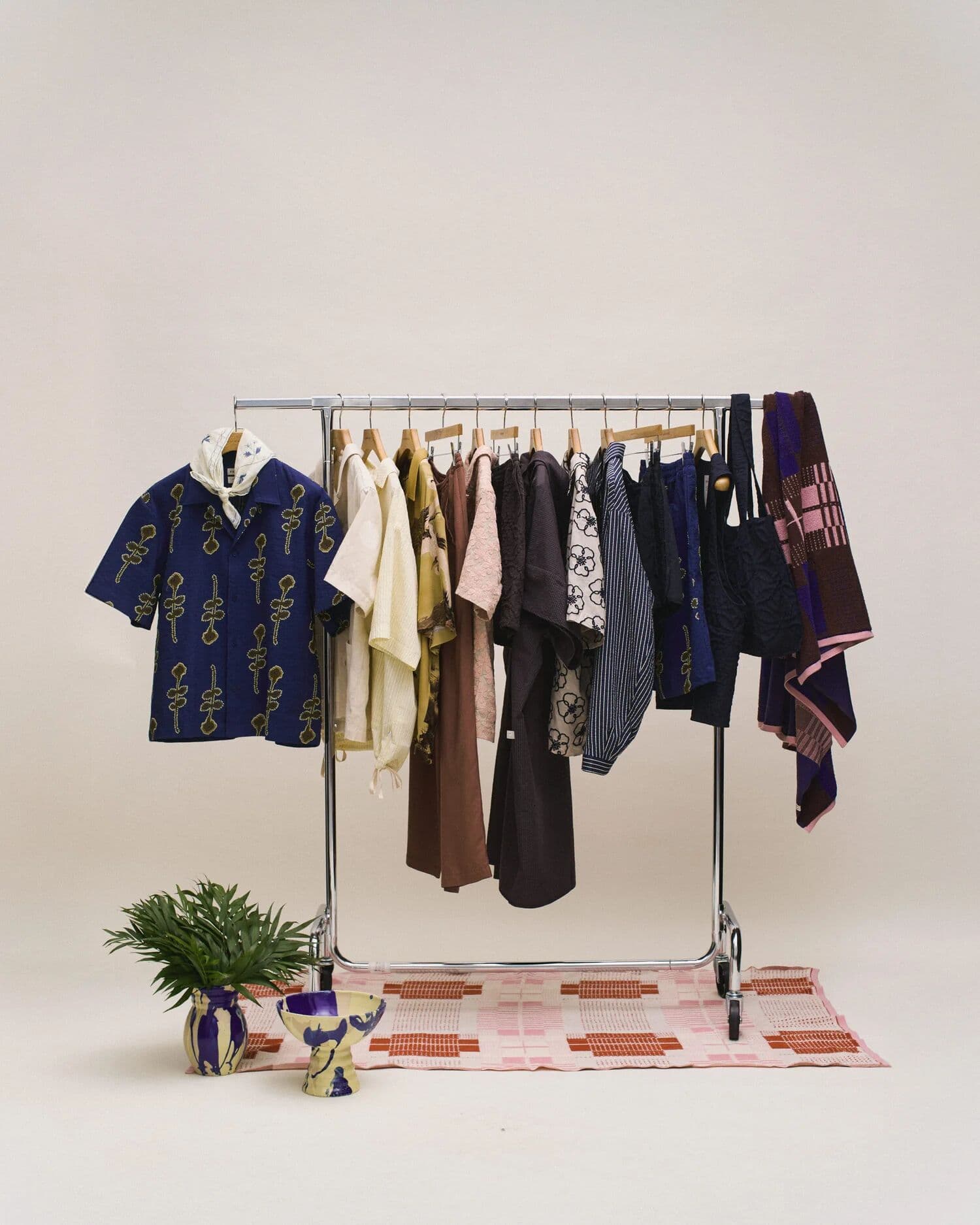 A styled rack of patterned shirts and dresses