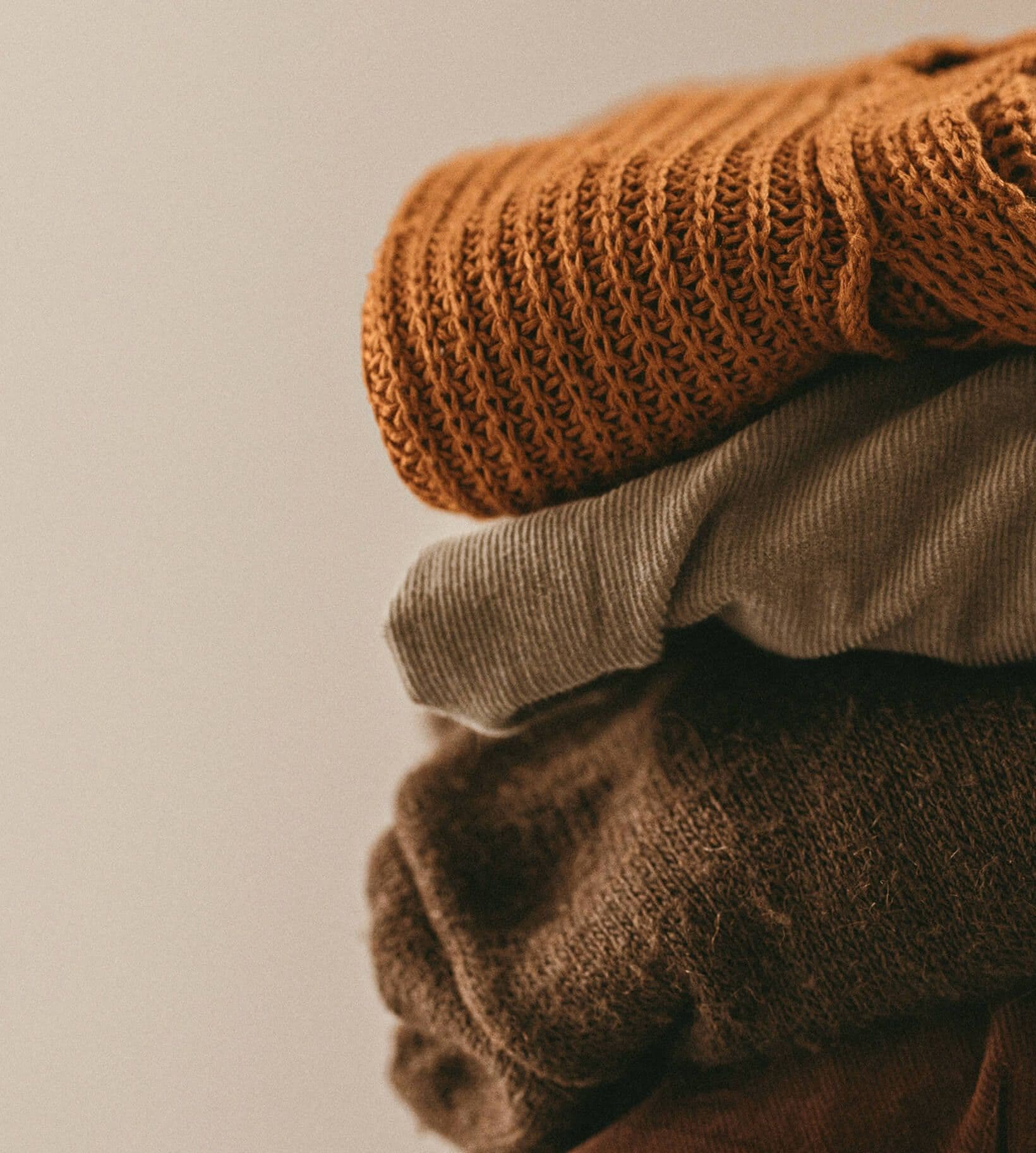 Wooden rail of shirts and jackets in a sunlit studio